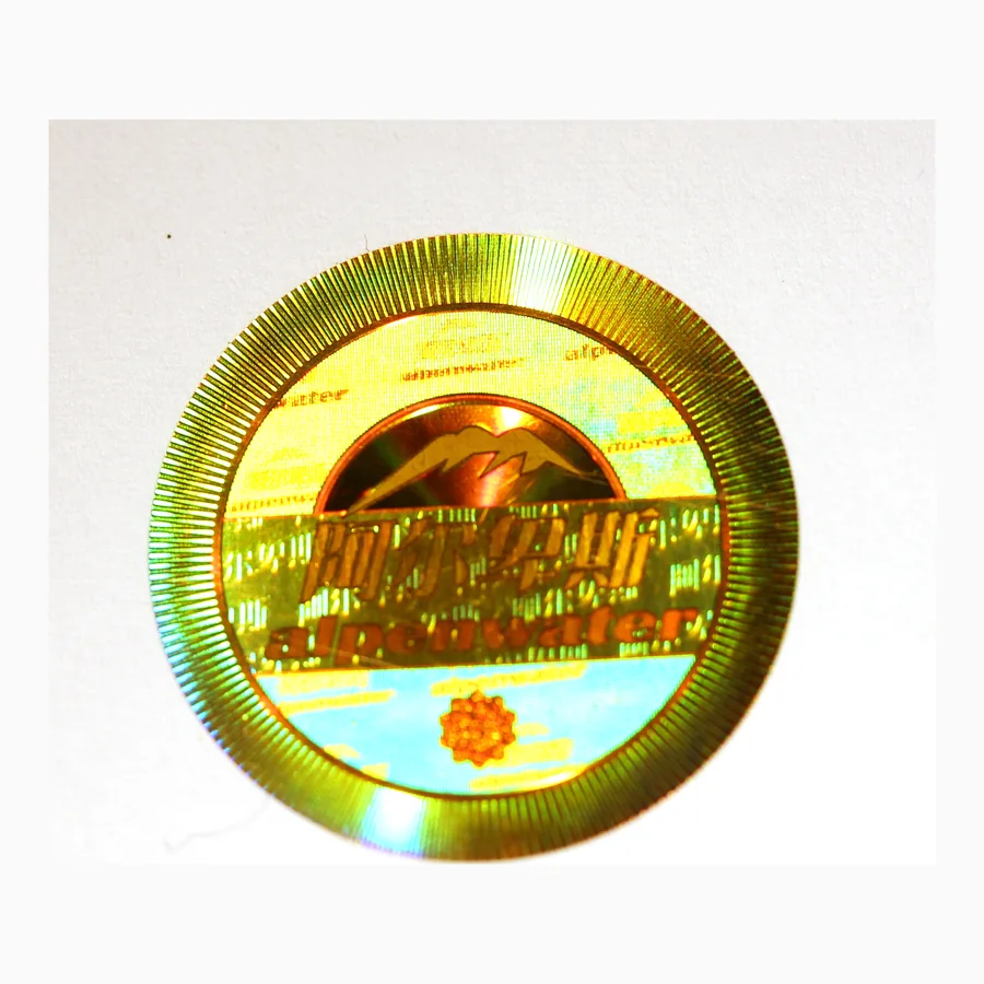 Circular holographic security label showing a radial diffraction pattern shifting through green and gold